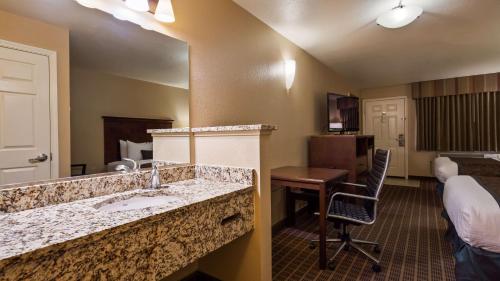 a hotel room with a bathroom with a sink and a mirror at Best Western Fallon Inn & Suites in Fallon