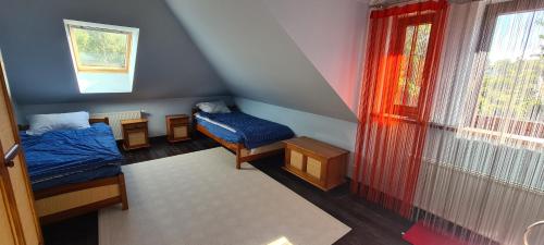 Cette petite chambre comprend 2 lits et une fenêtre. dans l'établissement MAZURSKI DOM, à Orzysz