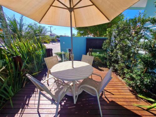 a table and chairs under an umbrella on a patio at Belle Arti Pousada in Florianópolis