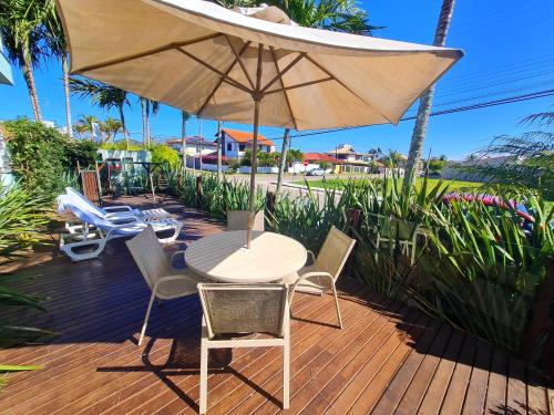 a table and chairs under an umbrella on a deck at Belle Arti Pousada in Florianópolis