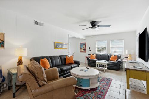 a living room with black leather furniture and a flat screen tv at Folly Vacation Great Location, Vintage and Fun 120 Unit B in Folly Beach