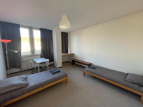 um quarto com duas camas, uma mesa e uma cadeira em Monteurwohnung in Stadtnähe em Hanôver