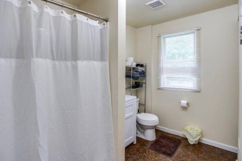 a bathroom with a white shower curtain and a toilet at Marvelous Colonial Mins to UofR/Airpt in Rochester