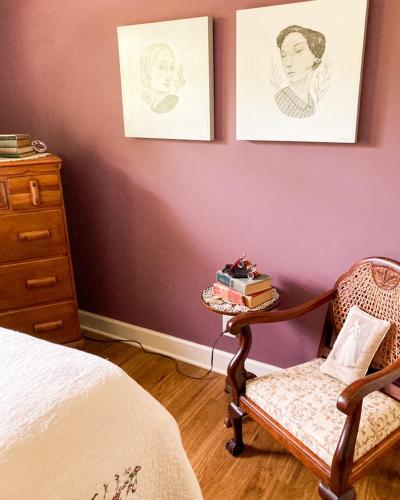a bedroom with a chair and a table with books at Glenn Meadow Bed and Breakfast in South Haven