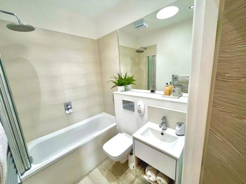 a bathroom with a sink and a toilet and a tub at The Penthouse Margate, Balconies, Sea View, Gated Parking, Air Con! in Margate