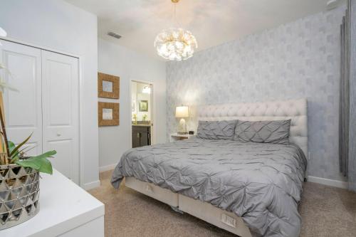 1 dormitorio con cama y lámpara de araña en Charming 4 bedroom house with Private Pool 1542, en Davenport