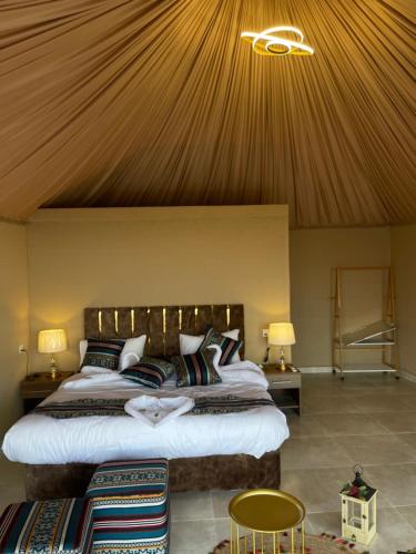 a bedroom with a large bed with a wooden ceiling at Rashed Luxury Camp in Wadi Rum