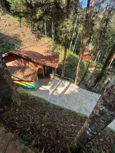 a picnic table with a wooden roof in a park at Recanto dos Sonhos Guest House in Lumiar