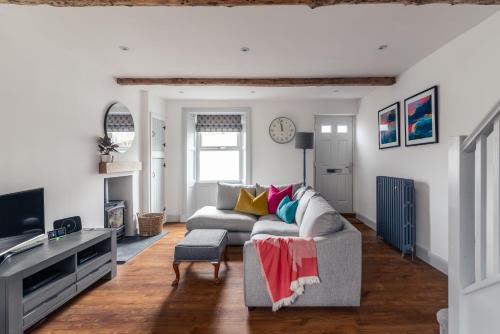 a living room with a couch and a tv at 59 Windermere Road, Kendal in Kendal