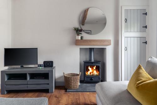 a living room with a fireplace and a television at 59 Windermere Road, Kendal in Kendal