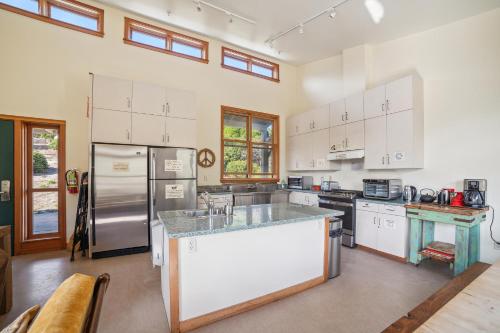 a kitchen with white cabinets and a stainless steel refrigerator at Limantour Lodge in Point Reyes Station