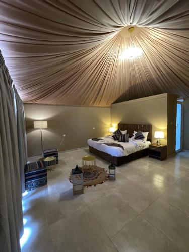 a bedroom with a large bed with a wooden ceiling at Rashed Luxury Camp in Wadi Rum