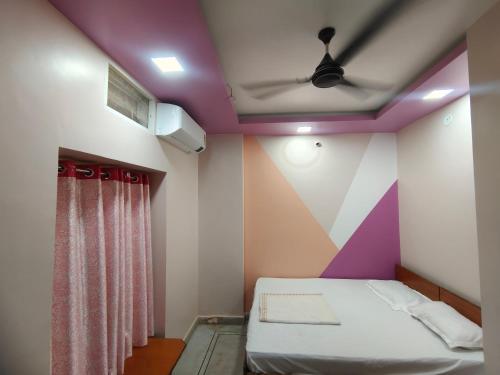 a room with a bed and a purple ceiling at HOTEL ANJALI in Ujjain