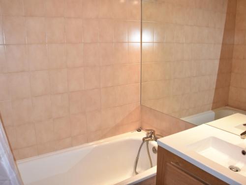une salle de bain avec une baignoire blanche et un lavabo dans l'établissement Appartement 3 pièces en plein centre, proche commerces et téléphérique, idéal famille ! - FR-1-464-126, à Pralognan-la-Vanoise