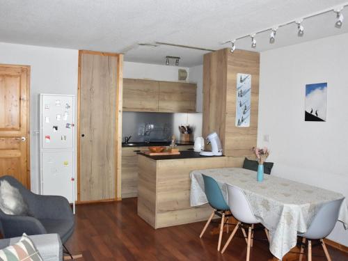une cuisine et une salle à manger avec une table et des chaises dans l'établissement Appartement 3 pièces en plein centre, proche commerces et téléphérique, idéal famille ! - FR-1-464-126, à Pralognan-la-Vanoise