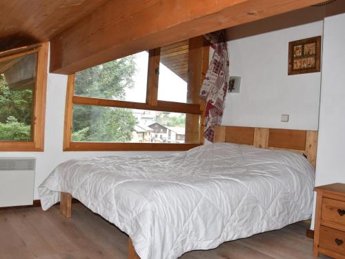 une chambre avec un lit et une grande fenêtre dans l'établissement Charmant duplex avec grande terrasse au cœur de Champagny-en-Vanoise - FR-1-464-38, à Champagny-en-Vanoise