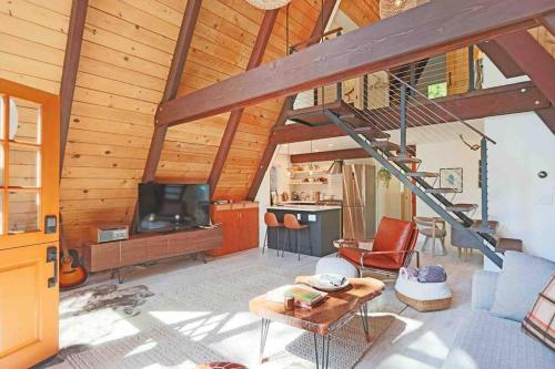 ein Wohnzimmer mit einer Treppe in einem Haus in der Unterkunft Mid Century Modern Cabin - The Tahoe A-Frame in Homewood