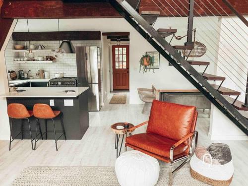 eine Küche mit einer Theke und einem Stuhl in einem Zimmer in der Unterkunft Mid Century Modern Cabin - The Tahoe A-Frame in Homewood