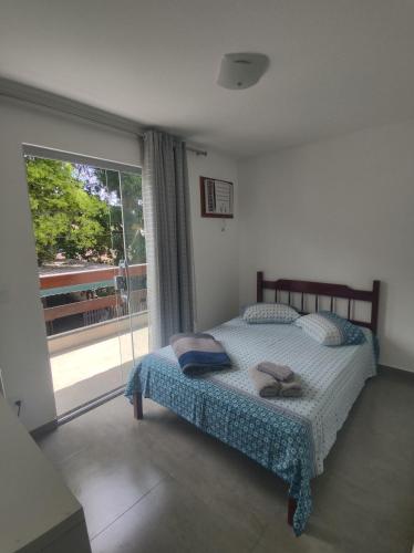 a bedroom with a bed and a large window at Residencial 101 Ilha Grande in Abraão
