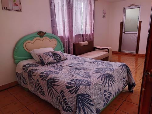 a bedroom with a bed with a blue and white comforter at Hotel Altamira Suites - Ibarra in Ibarra
