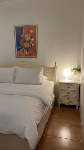 een slaapkamer met 2 bedden en een nachtkastje met een lamp bij Rynn Hotel in Trat