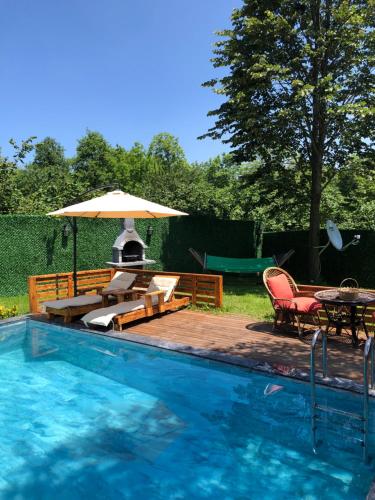 a swimming pool with a table and an umbrella at Sıcak havuzlu dağ evi in Sapanca