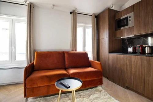 sala de estar con sofá marrón y mesa en Lovely studio - Pigalle Moulin Rouge, en París