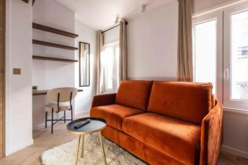 sala de estar con sofá naranja y mesa en Lovely studio - Pigalle Moulin Rouge, en París