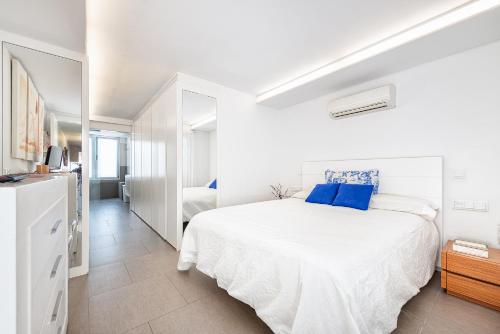 Salinetas的住宿－Luxury First Line Apartment.，白色卧室配有一张带蓝色枕头的大床