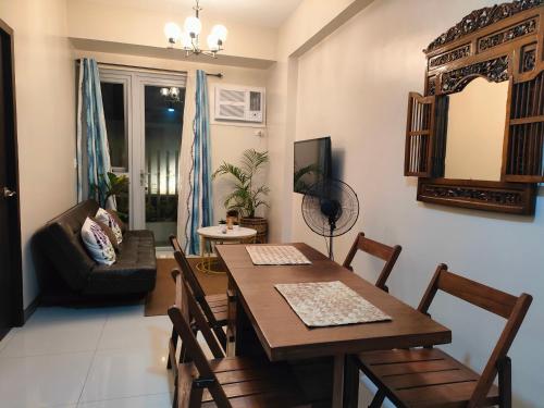 a living room with a dining room table and a couch at The Verdin at Maple Grove in Cavite