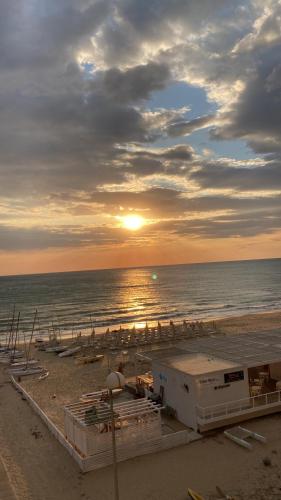 スコリッティにあるTerrazza sul mareの海に沈む夕日を望むビーチの景色