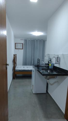 a bathroom with a sink and a bed in a room at Residencial 101 Ilha Grande in Abraão