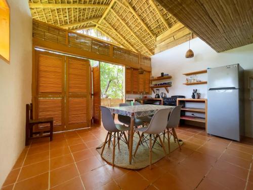 een keuken met een tafel en stoelen en een koelkast bij Posada La Sabila in Mazunte