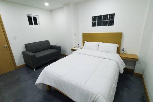 ein Schlafzimmer mit einem großen weißen Bett und einem Stuhl in der Unterkunft Lugar perfecto para descansar.²⁰³ in Fortín de las Flores