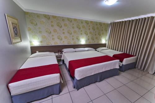 a bedroom with three beds in a room at Foz Plaza Hotel in Foz do Iguaçu