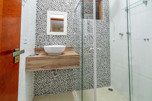 uma casa de banho com um lavatório e uma cabina de duche em vidro. em Pousada Cabeça do Indio - Trindade em Trindade