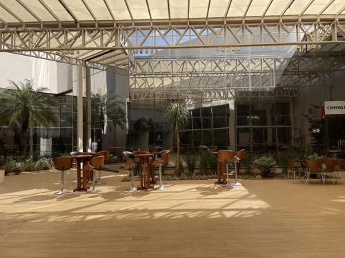 a courtyard with tables and chairs in a building at Transamerica Executive Maringá in Maringá
