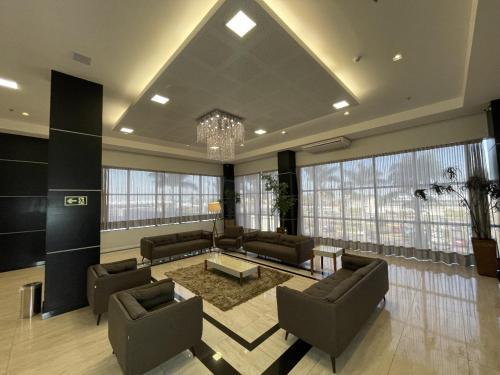 a large living room with couches and a chandelier at Transamerica Executive Maringá in Maringá
