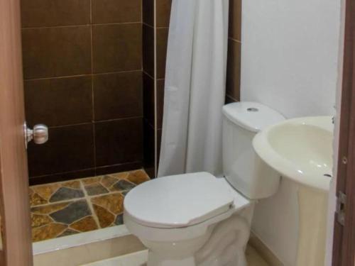 a bathroom with a toilet and a sink at Hostal Los Arhuacos in Santa Marta