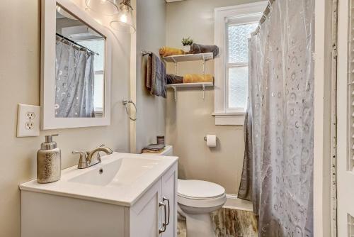 a bathroom with a sink and a toilet and a window at The White Len in Jacksonville