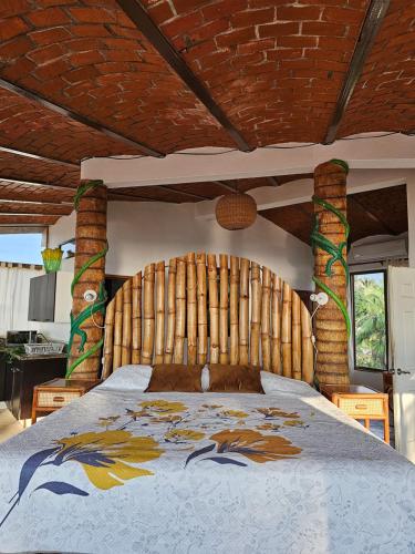 a bedroom with a large bed with a wooden headboard at Villa Corona del Mar in Rincon de Guayabitos