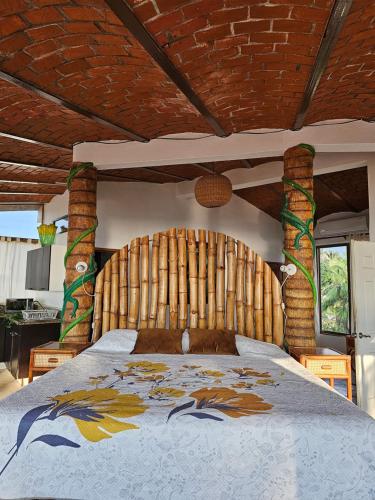 1 dormitorio con 1 cama grande y cabecero de madera en Villa Corona del Mar, en Rincón de Guayabitos