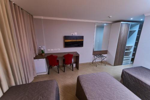 a hotel room with a bed and a table and chairs at Foz Plaza Hotel in Foz do Iguaçu