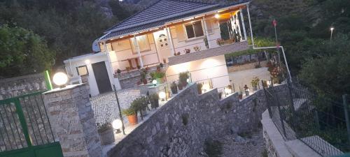 una casa su un muro di pietra con delle luci sopra di VILA CANI a Tepelenë