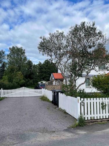 una cerca blanca frente a una casa blanca en Villa Rosenfors, en Rosenfors