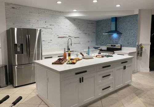 uma cozinha com armários brancos e um frigorífico de aço inoxidável em Serenity at Moon Bay! em Key Largo