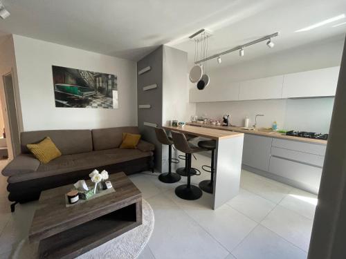 een woonkamer en een keuken met een bank en een tafel bij Apartman Rose Residency - SELF CHECK IN, FREE PARKING in Osijek
