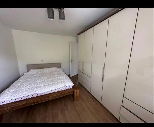 1 dormitorio con 1 cama y armarios blancos en Yigits Rooms, en Lucerna