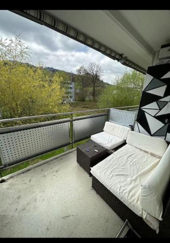 a balcony with a bed and a table on a roof at Yigits Rooms in Lucerne