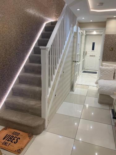 a staircase in a home with white tile flooring and a white stair case at Air Conditioned Modern Double Bed Room with Private Attached Bathroom - FREE Parking - Near London Heathrow Airport & Southall Broadway in Southall